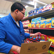 link to 'An Empathy Initiative' story image of a grocery store clerk stocking shelves