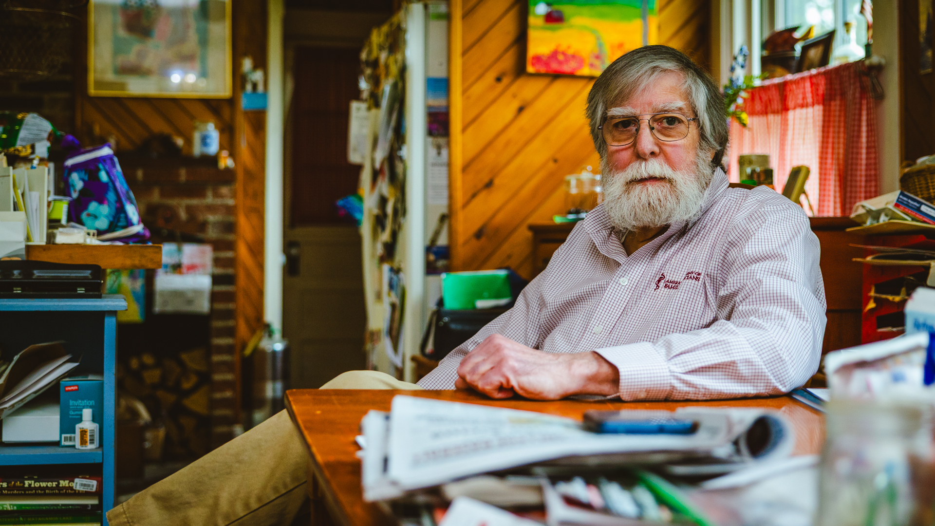 Photo of Dr. Ronald Blum in his nice home by his table.